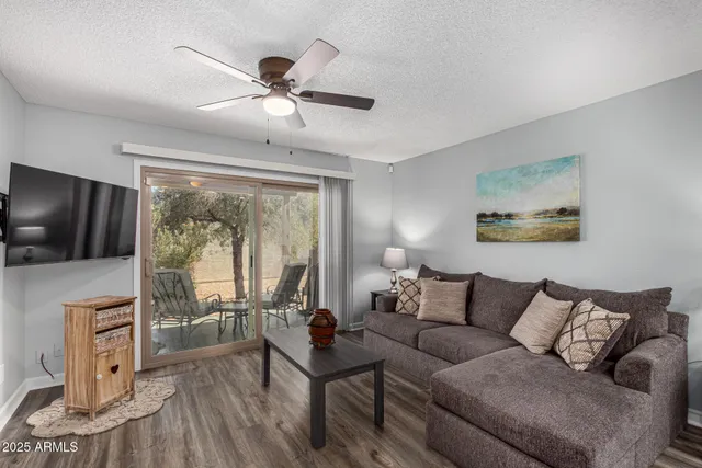 a living room with furniture and a flat screen tv with kitchen view