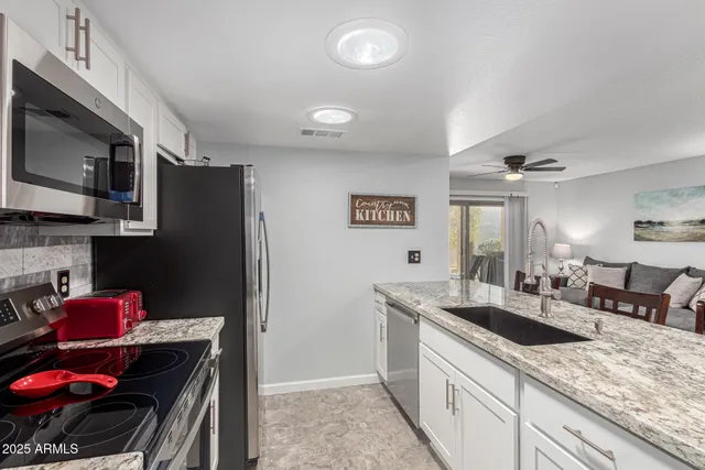 a kitchen with stainless steel appliances granite countertop a sink stove and refrigerator