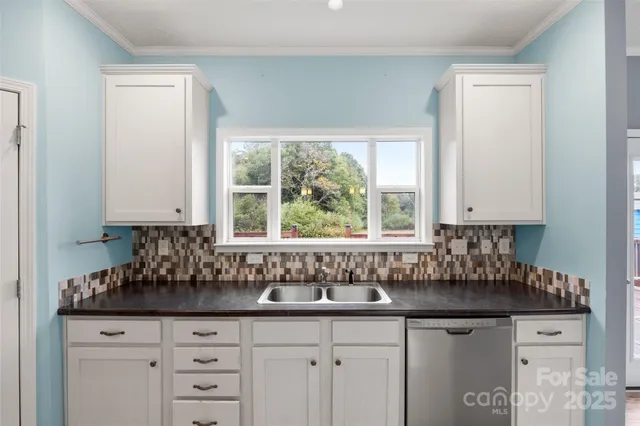 a view of a kitchen with a sink a refrigerator and window