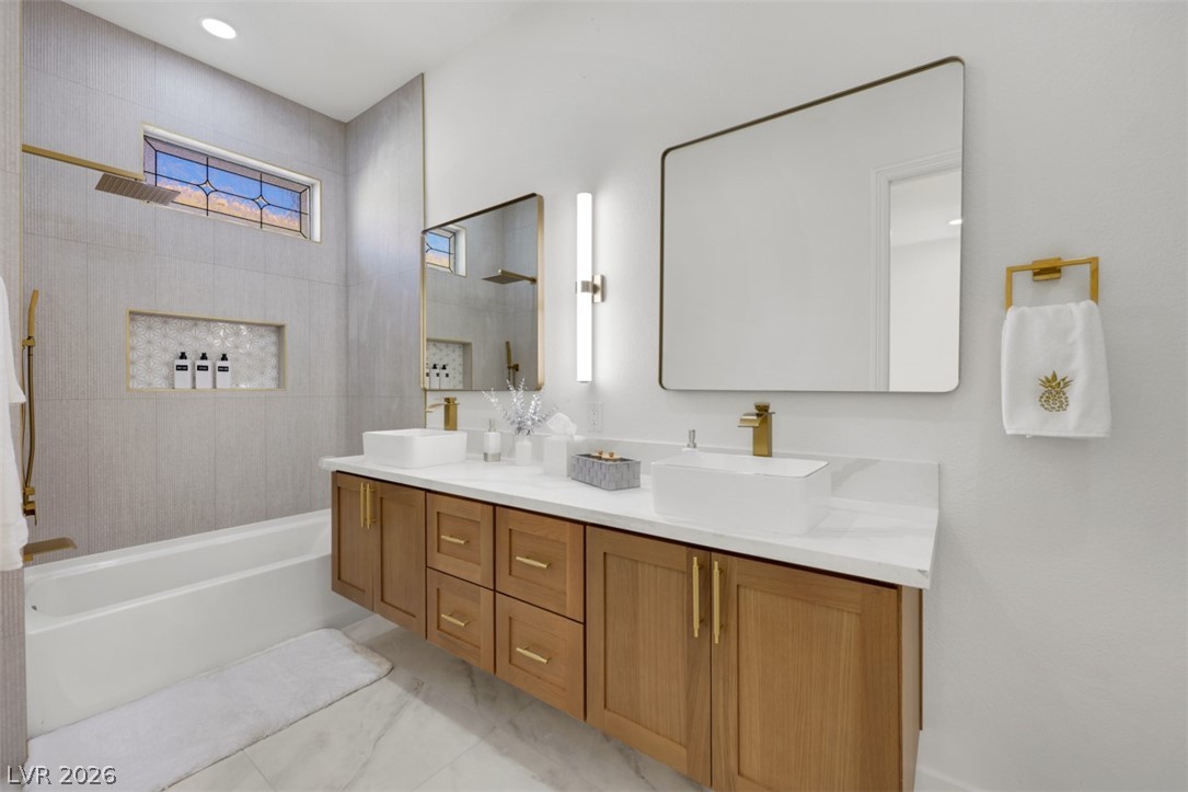 5015 Rivedro Street Las Vegas, NV 89135 - Photo 2 of 91 Modern double vanity with dual vessel sinks complements the elegant marble flooring and deep soaking tub.