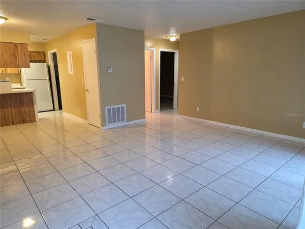 a view of a kitchen with furniture and a refrigerator