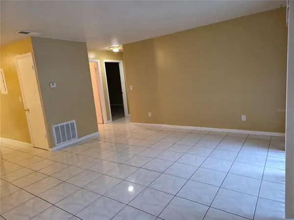 a view of a livingroom with an empty space and a window
