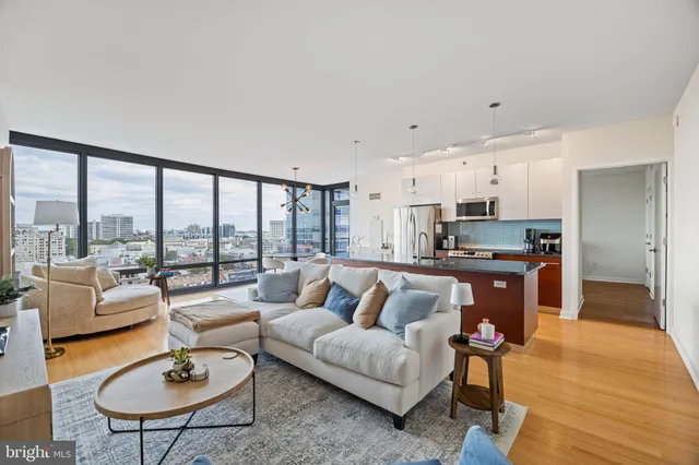 a living room with furniture and a dining table with kitchen view