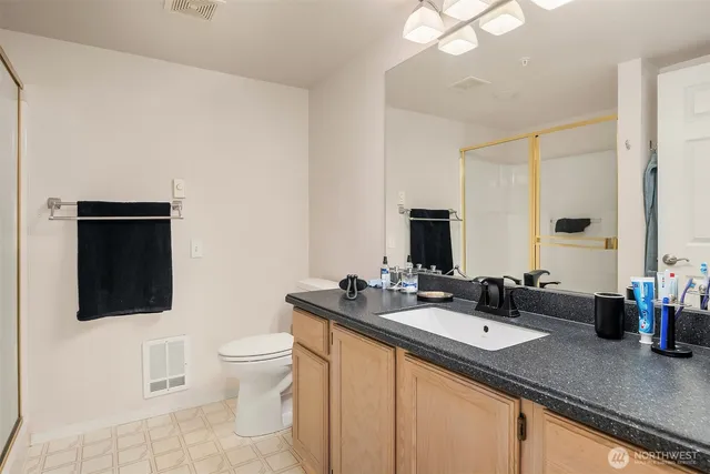 a bathroom with a sink double vanity granite and a toilet