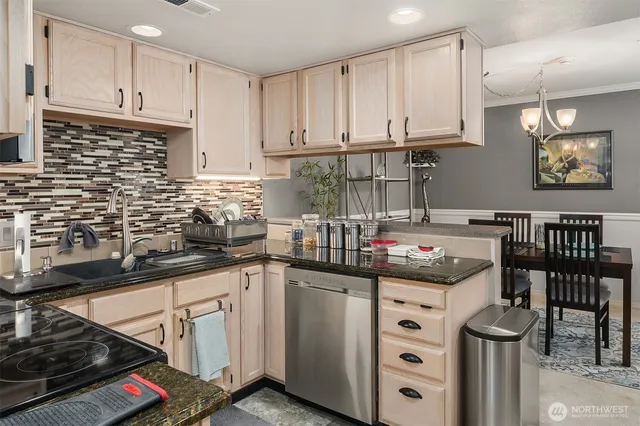 a kitchen with granite countertop a sink a stove and cabinets