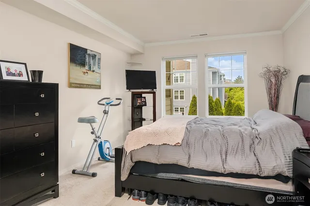 a bedroom with a bed and a flat tv screen on dresser