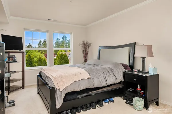 a bedroom with a bed and a flat tv screen on the dresser