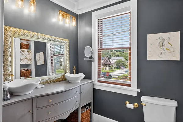a bathroom with a granite countertop sink a large mirror and a window