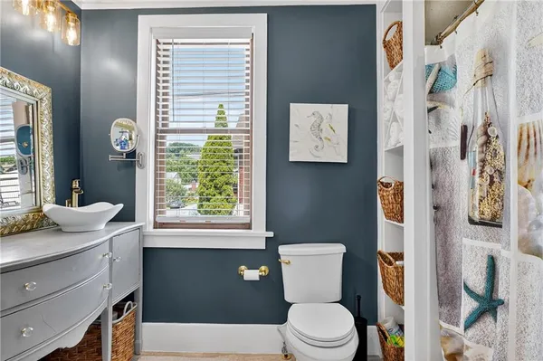 a bathroom with a sink a toilet and a window