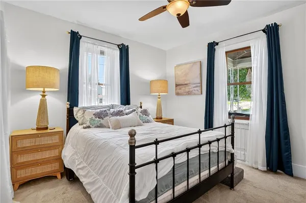 a bedroom with a bed a lamp on dresser and a window