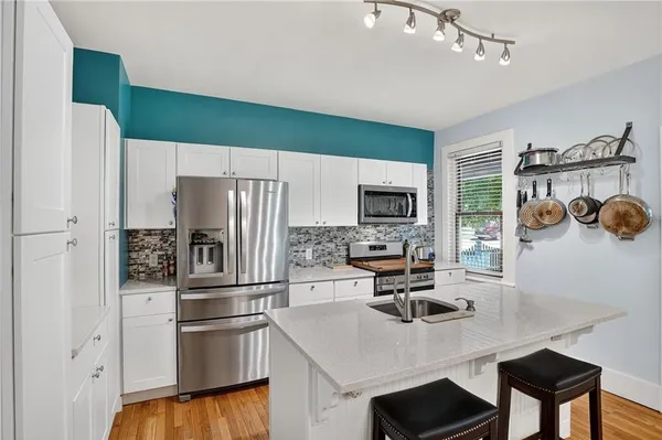 a kitchen with a refrigerator and a stove top oven
