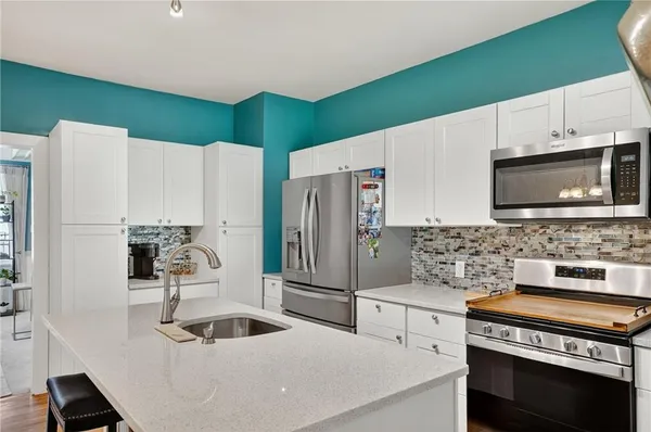 a kitchen with stainless steel appliances a stove a sink and a microwave