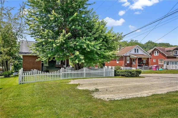 a view of a house with a backyard and a tree