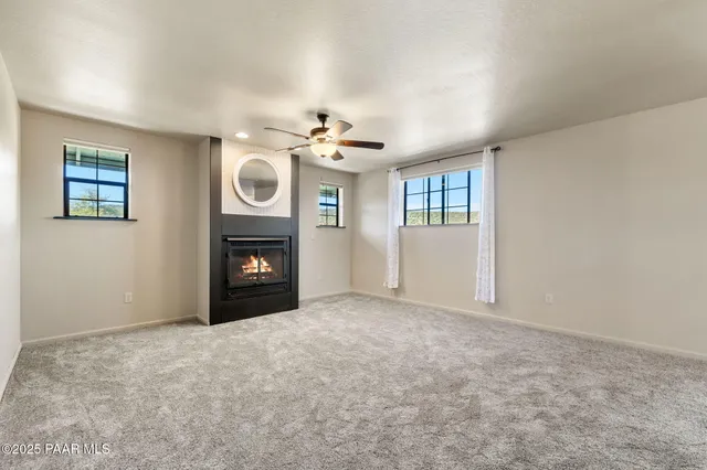 a view of an empty room with a fireplace and a window