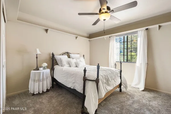 a spacious bedroom with a bed and a chandelier