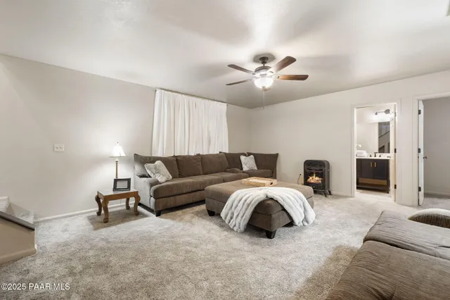 a living room with furniture and a ceiling fan