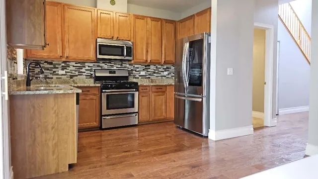 a kitchen with stainless steel appliances granite countertop a stove a refrigerator and a microwave