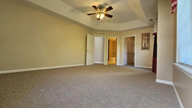 an empty room with a ceiling fan and a window