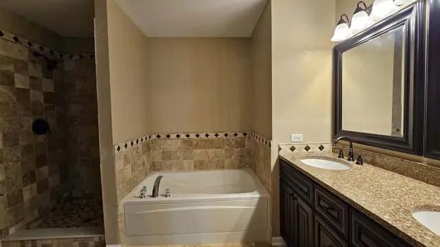a bathroom with a granite countertop sink a mirror and shower
