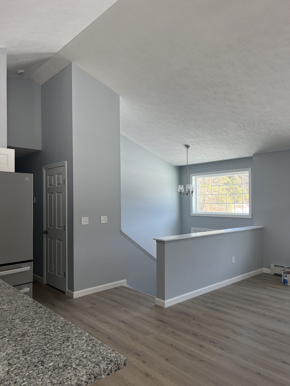 246 Holtshire Road, Unit LOT 3 Orange, MA 01364 - Photo 13 of 16 an empty room with wooden floor cabinet and windows