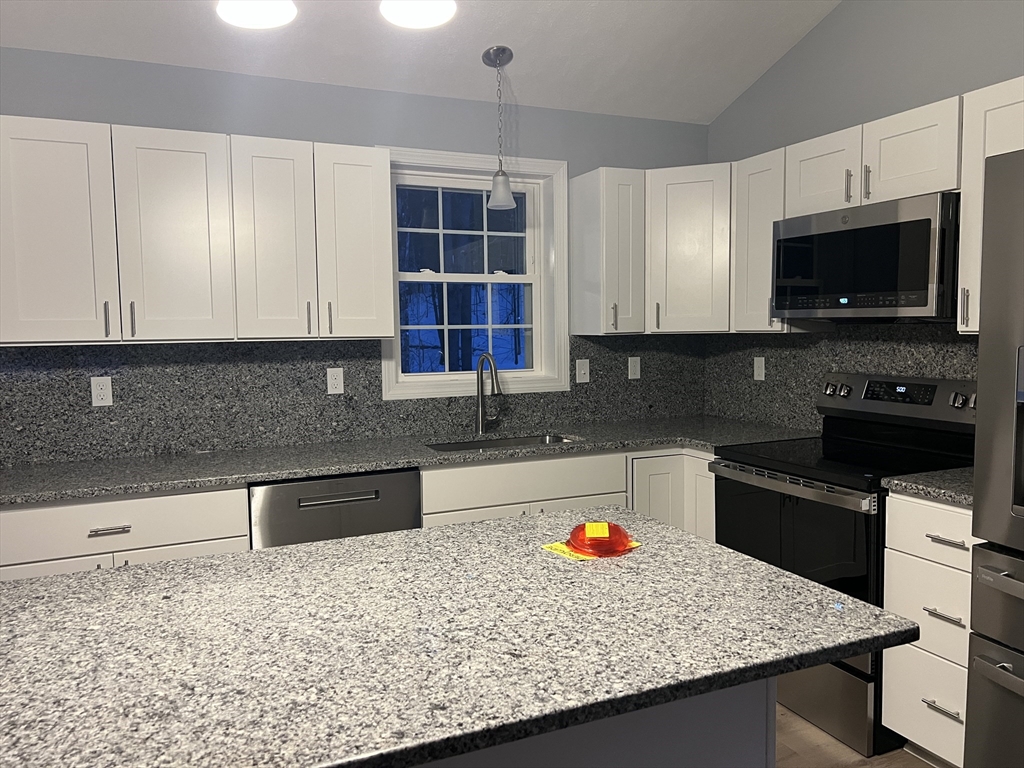 246 Holtshire Road, Unit LOT 3 Orange, MA 01364 - Photo 14 of 16 a kitchen with granite countertop a sink a stove and a microwave