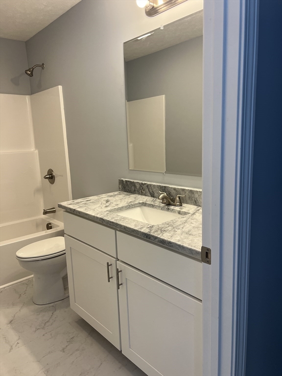 246 Holtshire Road, Unit LOT 3 Orange, MA 01364 - Photo 6 of 16 a bathroom with a granite countertop toilet a sink and a mirror