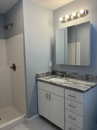 a bathroom with a granite countertop sink and a mirror
