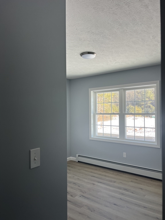 246 Holtshire Road, Unit LOT 3 Orange, MA 01364 - Photo 10 of 16 an empty room with wooden floor and windows
