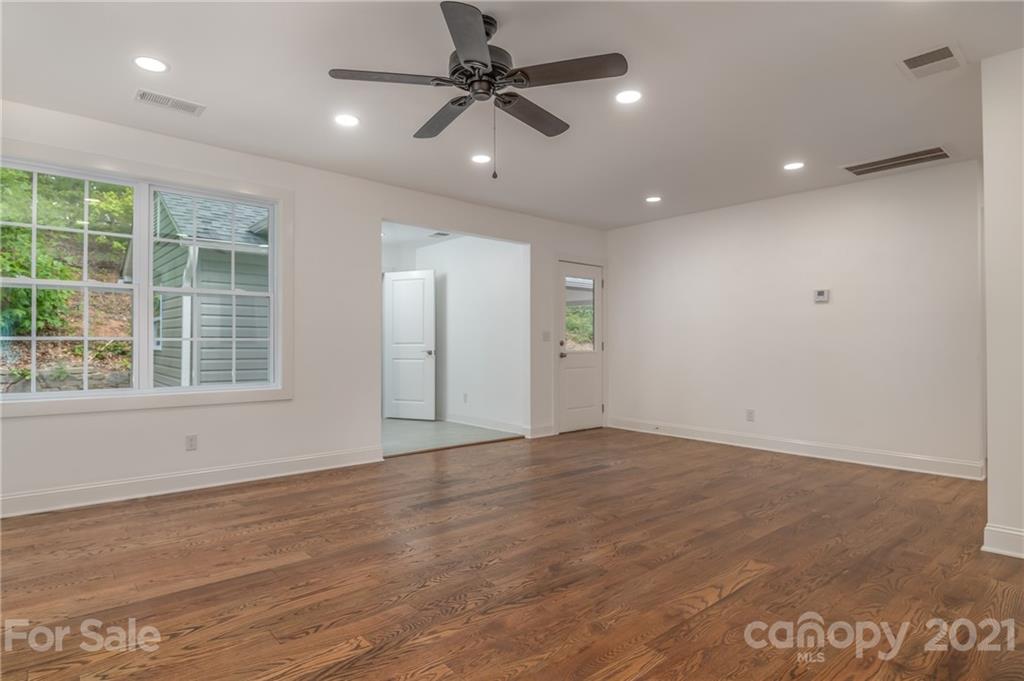 555 New Market Road Tryon, NC 28782 - Photo 8 of 37 an empty room with wooden floor and windows