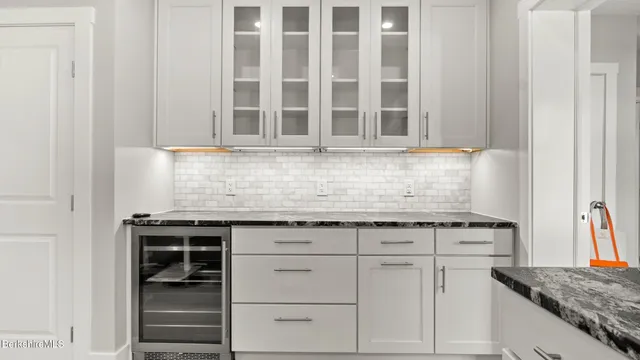 a bathroom with a granite countertop sink and a bathtub