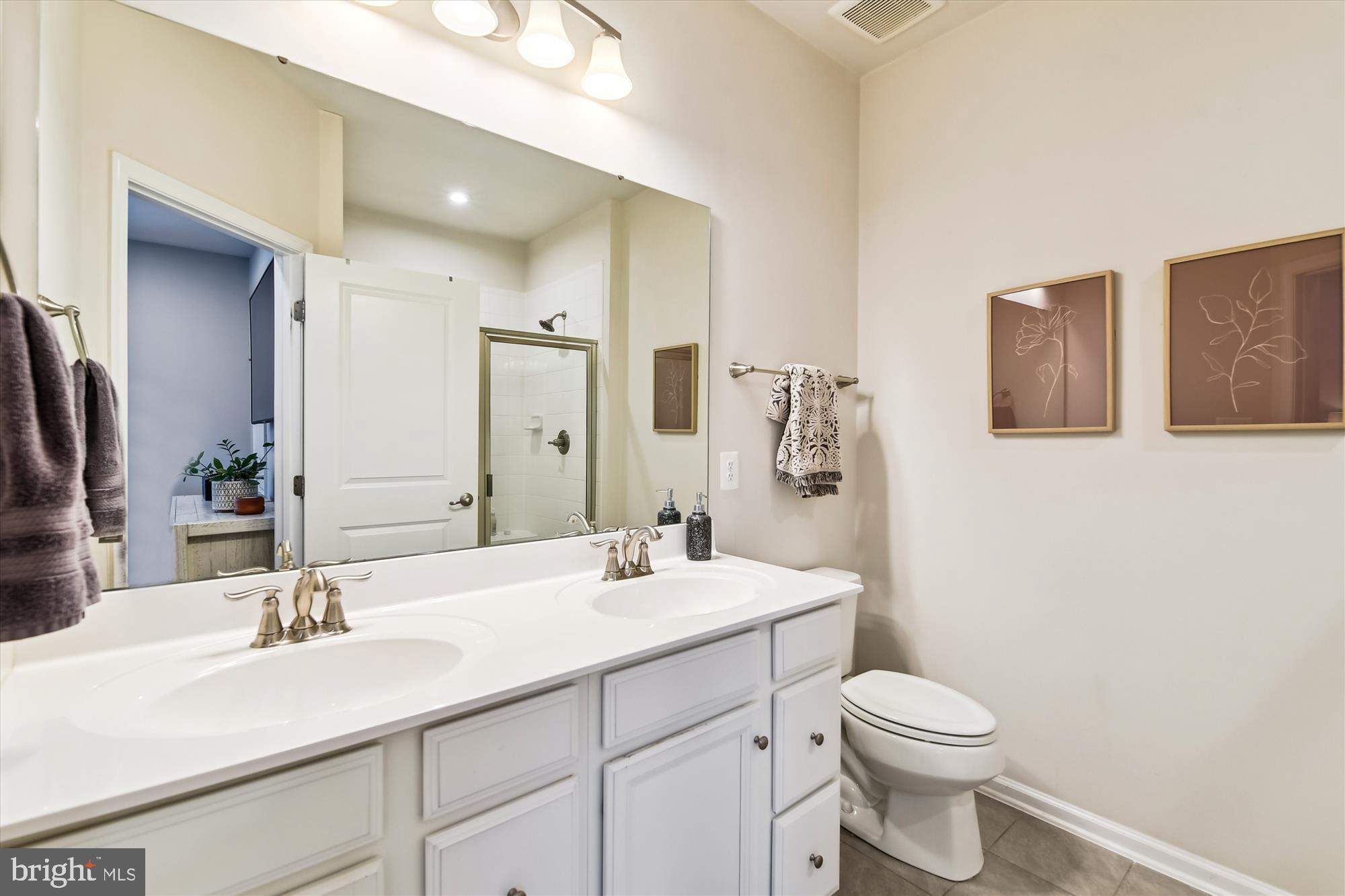 2907 Shaws Road Edgemere, MD 21219 - Photo 16 of 36 a bathroom with a double vanity sink toilet and mirror