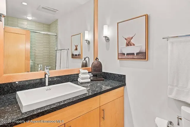a bathroom with a granite countertop sink a mirror and vanity