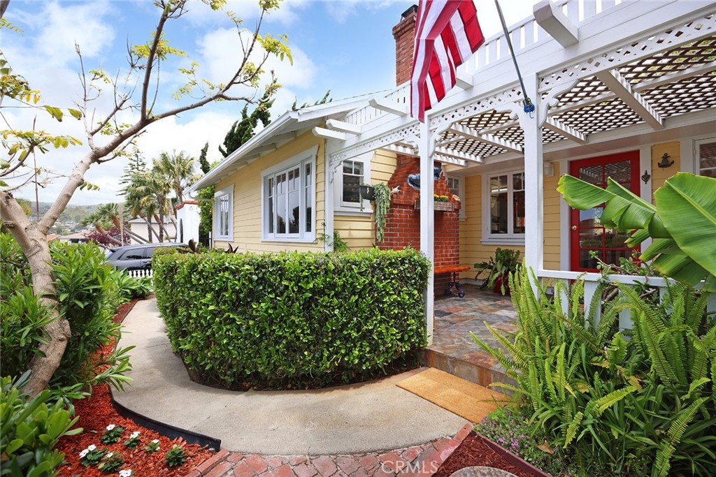 556 Through Street Laguna Beach, CA 92651 - Photo 3 of 30 a view of a white house with large windows and a flower garden