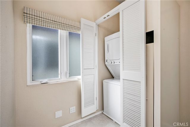 an empty room with chandelier fan and windows
