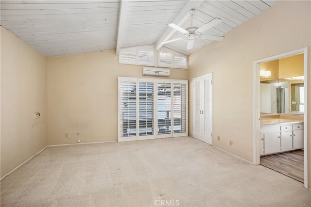 a view of an empty room with a chandelier fan