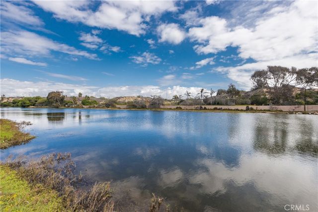 a sign that is sitting in the grass near a tree
