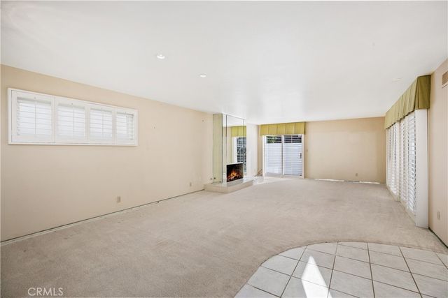 a view of an empty room with wooden floor and windows