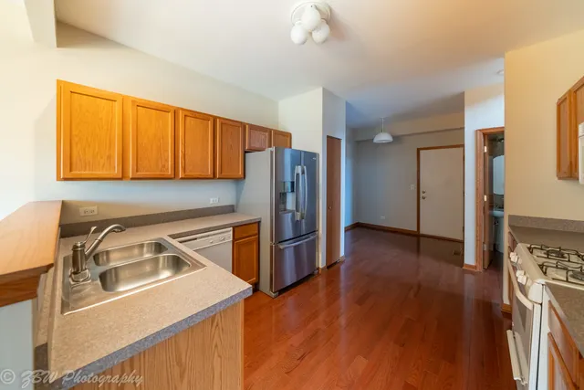 a kitchen that has a sink a stove and a refrigerator