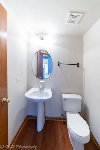 a bathroom with a toilet a sink and mirror