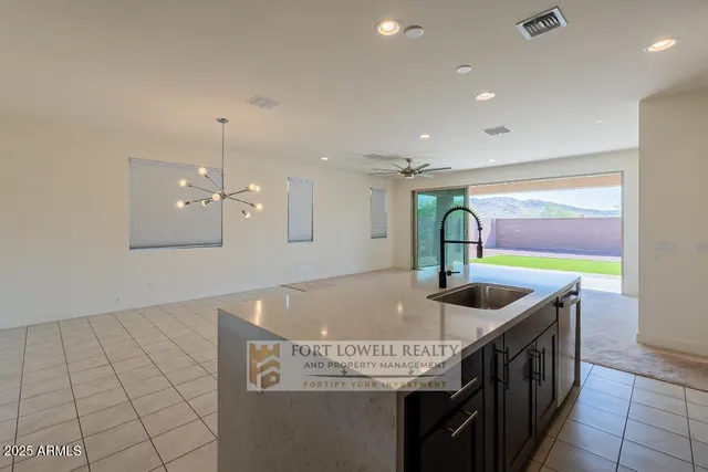 a kitchen with kitchen island a stove and a sink