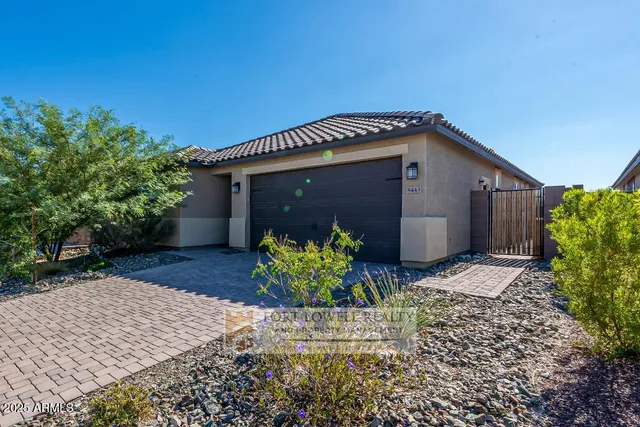 a front view of house with yard and trees in the background