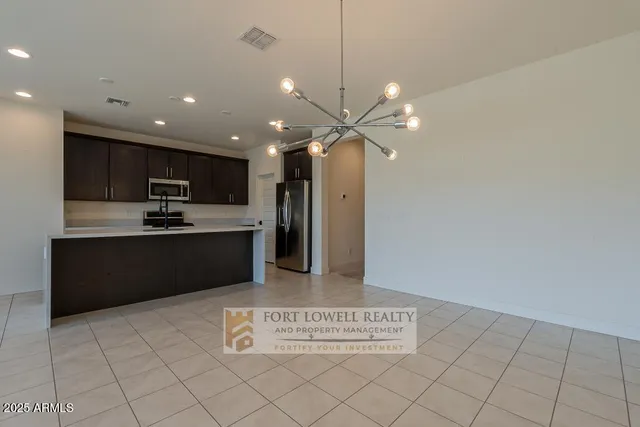 a kitchen with kitchen island granite countertop a refrigerator oven a sink and dishwasher