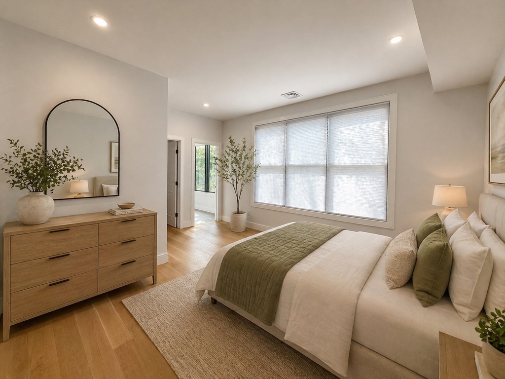 809-811 Heath Street, Unit 811 Brookline, MA 02467 - Photo 26 of 35 a spacious bedroom with a large bed and a dresser