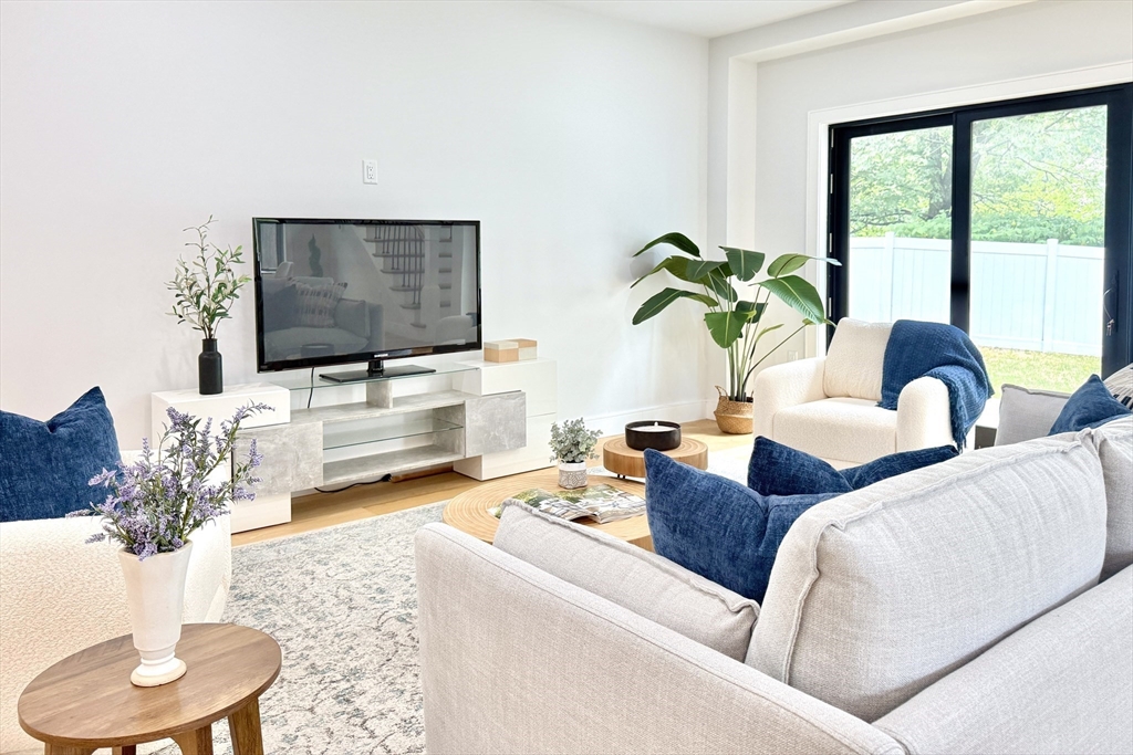 809-811 Heath Street, Unit 811 Brookline, MA 02467 - Photo 9 of 35 a living room with furniture and a flat screen tv