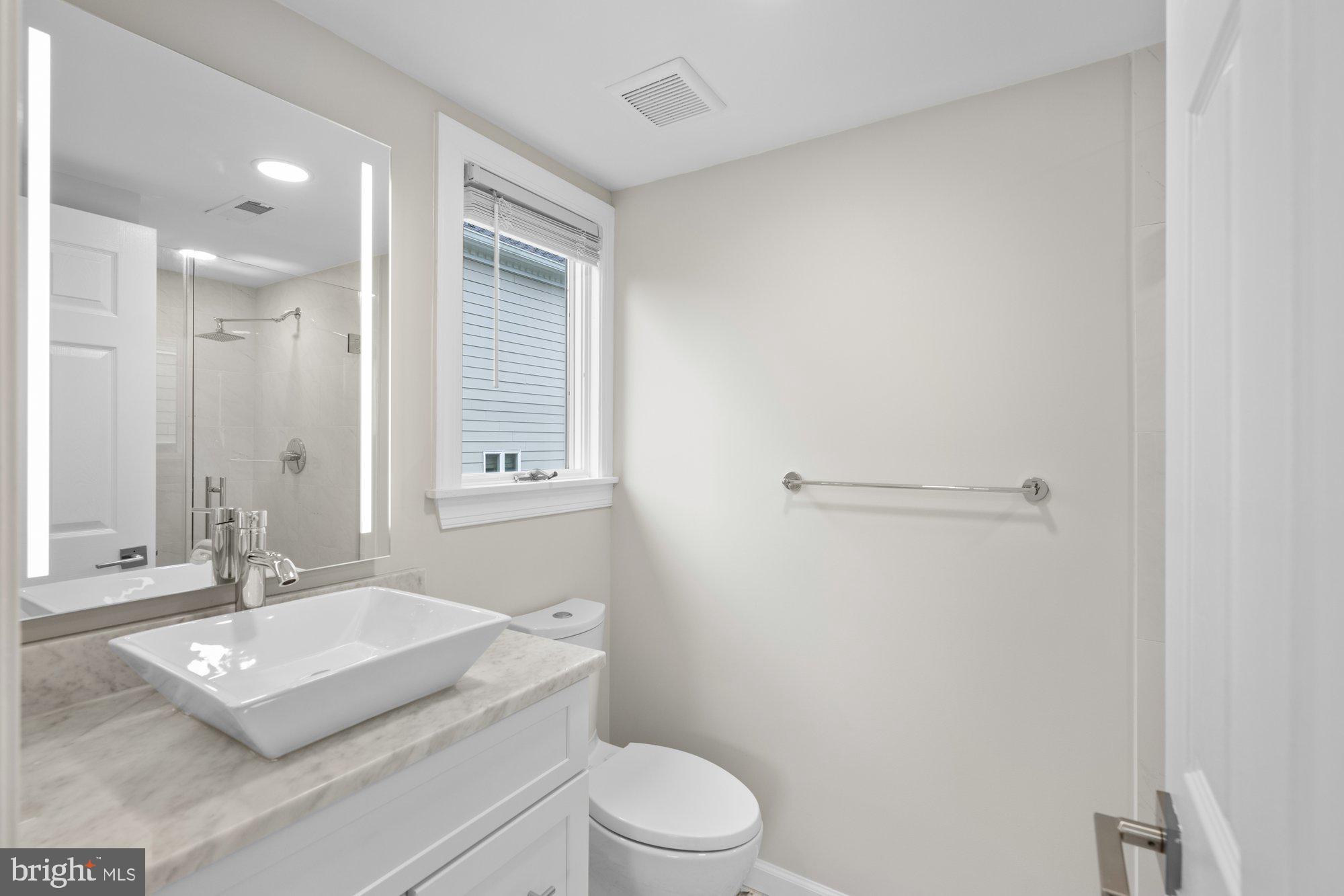 6856 St Albans Road McLean, VA 22101 - Photo 27 of 45 a bathroom with a granite countertop sink toilet a mirror and shower