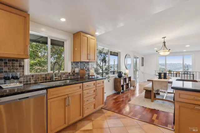 a kitchen with stainless steel appliances granite countertop a stove a sink and a refrigerator