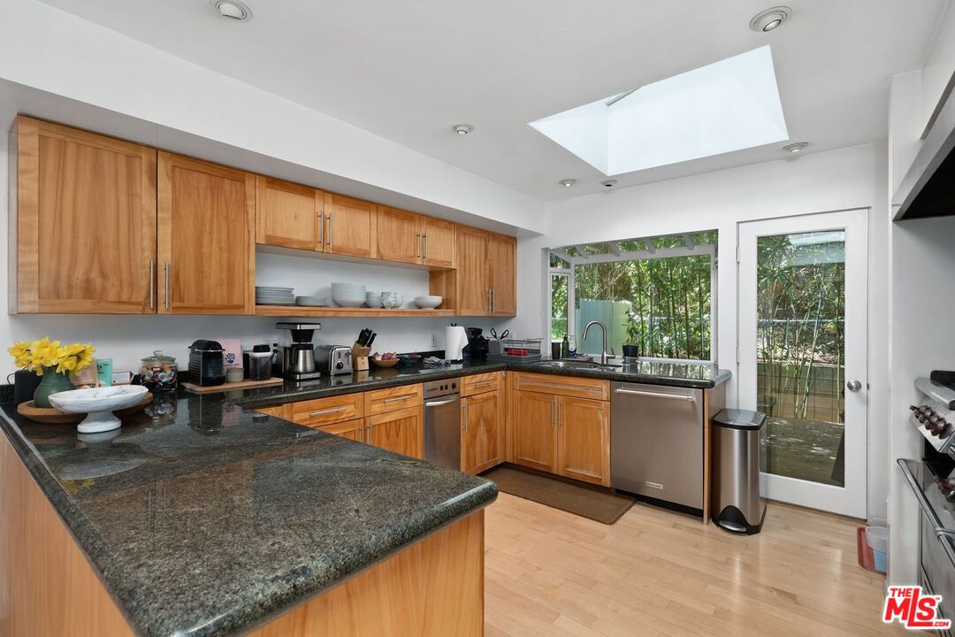 1827 Old Ranch Road Los Angeles, CA 90049 - Photo 11 of 39 a kitchen with stainless steel appliances granite countertop sink stove and cabinets