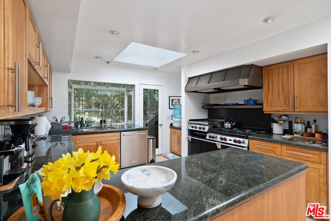 1827 Old Ranch Road Los Angeles, CA 90049 - Photo 12 of 39 a kitchen with stainless steel appliances granite countertop a sink stove and refrigerator