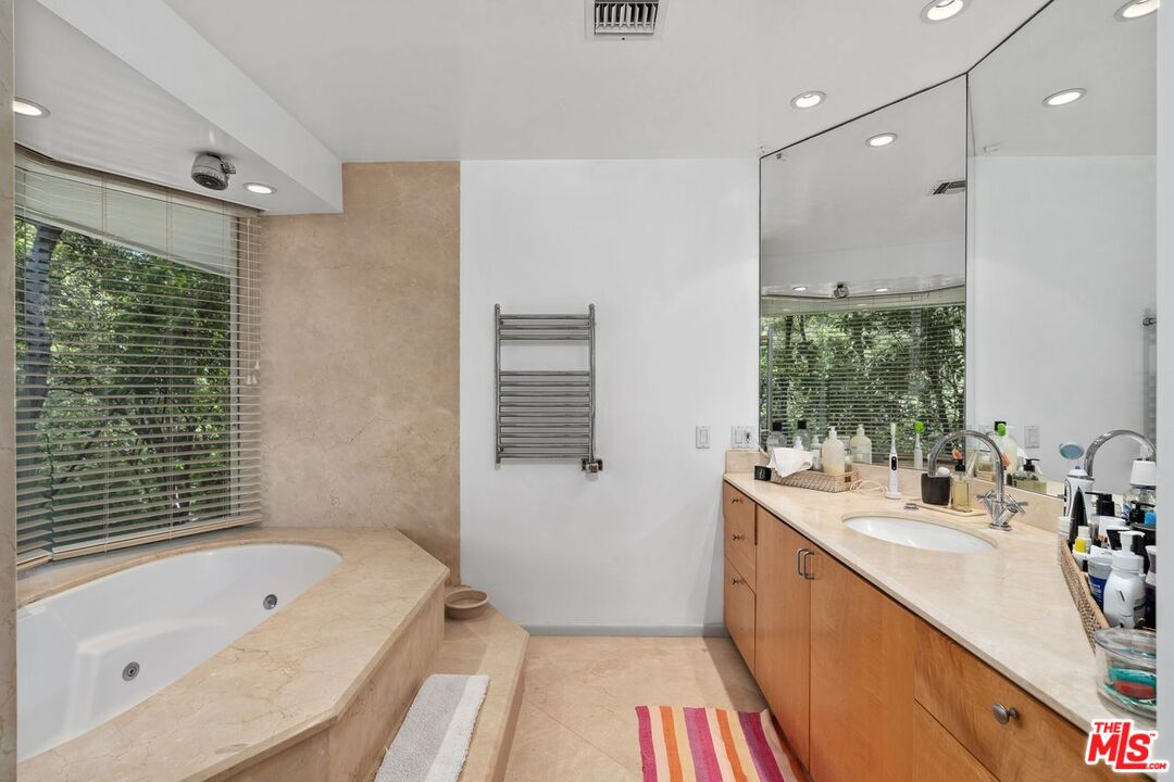 1827 Old Ranch Road Los Angeles, CA 90049 - Photo 28 of 39 a bathroom with a tub a sink a large mirror a vanity and a shower