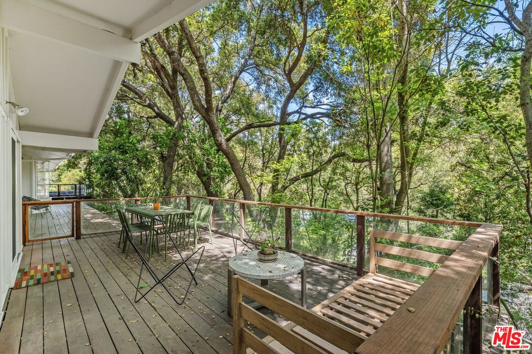 1827 Old Ranch Road Los Angeles, CA 90049 - Photo 32 of 39 a view of a roof deck with table and chairs and wooden floor